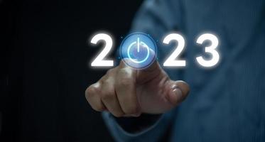 Businessperson touching icon power on 2023 virtual screen.ides success and target and plan concept. photo