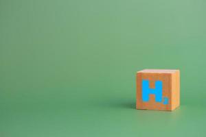 wood cube block h2 hydrogen on table. photo