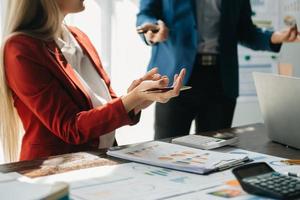 hombre de negocios y equipo analizando la tarea financiera de los estados financieros. con teléfono inteligente y computadora portátil y tableta. concepto de gestión de riqueza foto