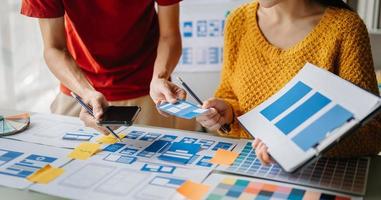 asiático empresario y mujer personas reunión en oficina. empleado idea genial y trabajo como equipo, plan y discutir proyecto por punto en papel y tableta. foto