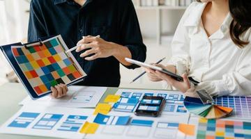 vista del equipo de desarrolladores de ui haciendo una lluvia de ideas sobre su proyecto con una computadora portátil, un teléfono inteligente y una tableta digital. agencia creativa de desarrollo digital. foto