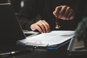 hombre mano estampado aprobación firma en documento o papeleo contrato a escritorio. foto