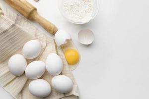 Baking cooking ingredients flour eggs rolling pin and kitchen textiles on a white background. Cookie pie or cake recipe mockup photo