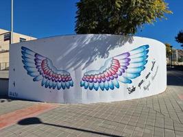 place painted colorful large wings on the white wall of the building Alicante Spain photo