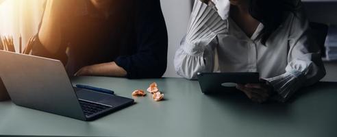 Group of confident business people point to graphs and charts to analyze market data, balance sheet, account, net profit to plan new sales strategies to increase production capacity. photo