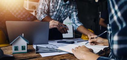 Image of engineering objects on workplace with three partners interacting on background photo