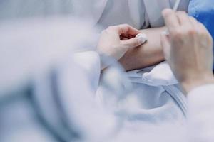 Side view of diverse doctors examining Asian female patient in bed in ward at hospital. photo