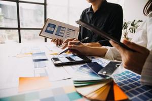 Close up ux developer and ui designer brainstorming about mobile app interface wireframe design on table with customer breif and color code at modern office.Creative digital development agency photo