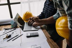 Image of engineering objects on workplace with three partners interacting on background photo