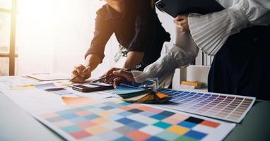 Close up ux developer and ui designer brainstorming about mobile app interface wireframe design on table with customer breif and color code at modern office.Creative digital development agency photo