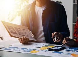 Close up ux developer and ui designer brainstorming about mobile app interface wireframe design on table with customer breif and color code at modern office.Creative digital development agency photo
