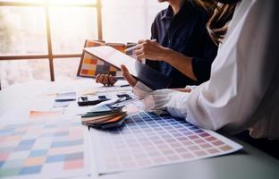 Close up ux developer and ui designer brainstorming about mobile app interface wireframe design on table with customer breif and color code at modern office.Creative digital development agency photo