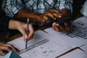 Image of engineering objects on workplace with three partners interacting on background photo