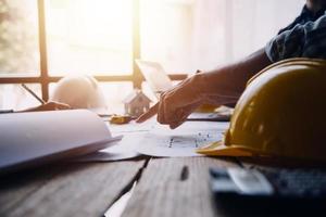Image of engineering objects on workplace with three partners interacting on background photo