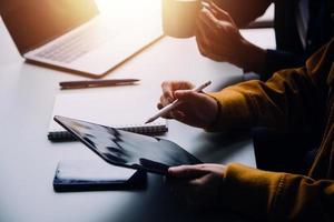 Group of confident business people point to graphs and charts to analyze market data, balance sheet, account, net profit to plan new sales strategies to increase production capacity. photo