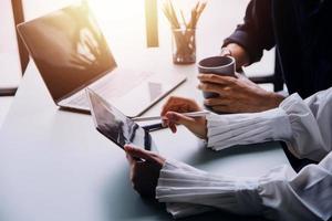 Group of confident business people point to graphs and charts to analyze market data, balance sheet, account, net profit to plan new sales strategies to increase production capacity. photo