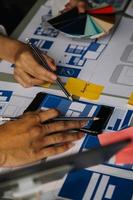 Close up ux developer and ui designer brainstorming about mobile app interface wireframe design on table with customer breif and color code at modern office.Creative digital development agency photo