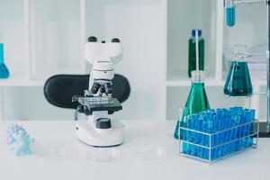 equipo científico de investigación bioquímica que trabaja con microscopio para el desarrollo de vacunas contra el coronavirus en laboratorios de investigación farmacéutica, enfoque selectivo foto