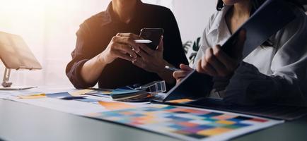 Close up ux developer and ui designer brainstorming about mobile app interface wireframe design on table with customer breif and color code at modern office.Creative digital development agency photo