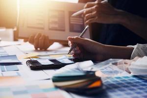 Close up ux developer and ui designer brainstorming about mobile app interface wireframe design on table with customer breif and color code at modern office.Creative digital development agency photo