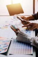 Close up ux developer and ui designer brainstorming about mobile app interface wireframe design on table with customer breif and color code at modern office.Creative digital development agency photo