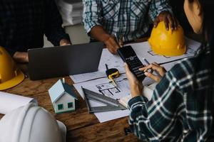 Image of engineering objects on workplace with three partners interacting on background photo