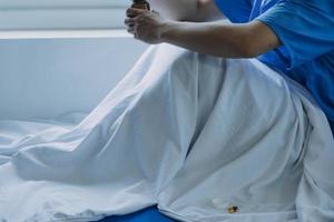 Side view of diverse doctors examining Asian female patient in bed in ward at hospital. photo