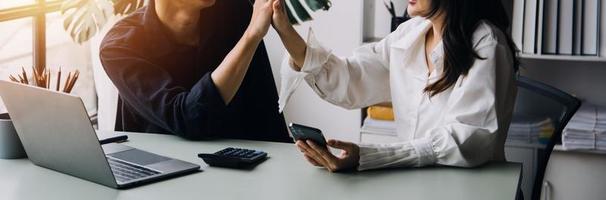 Group of confident business people point to graphs and charts to analyze market data, balance sheet, account, net profit to plan new sales strategies to increase production capacity. photo