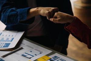 Close up ux developer and ui designer brainstorming about mobile app interface wireframe design on table with customer breif and color code at modern office.Creative digital development agency photo