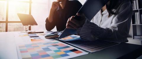 Close up ux developer and ui designer brainstorming about mobile app interface wireframe design on table with customer breif and color code at modern office.Creative digital development agency photo