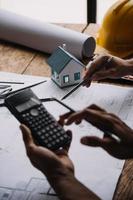 Image of engineering objects on workplace with three partners interacting on background photo