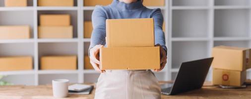Entrepreneurs Small Business SME Independent men work at home Use smartphones and laptops for commercial checking, online marketing, packing boxes, SME sellers, concept, e-commerce team, online sales photo