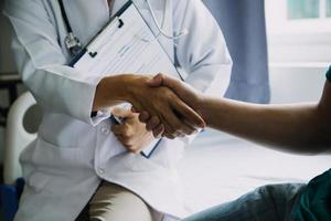 close up of patient and doctor taking notes photo