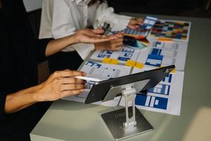 Close up ux developer and ui designer brainstorming about mobile app interface wireframe design on table with customer breif and color code at modern office.Creative digital development agency photo