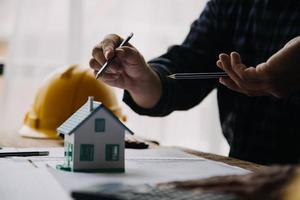 Image of engineering objects on workplace with three partners interacting on background photo