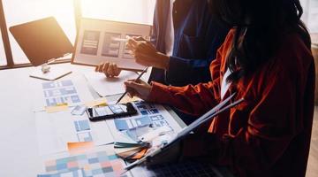 Close up ux developer and ui designer brainstorming about mobile app interface wireframe design on table with customer breif and color code at modern office.Creative digital development agency photo