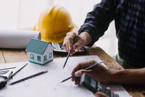 Image of engineering objects on workplace with three partners interacting on background photo