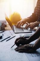 Image of engineering objects on workplace with three partners interacting on background photo