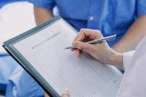 lado ver de diverso doctores examinando asiático hembra paciente en cama en sala a hospital. foto