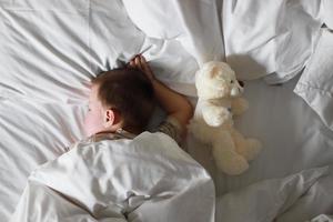 Baby sleeping with teddy bear photo