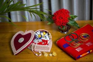 Handmade fiber ornaments box with traditional jewelry on the wooden table. Indian traditional jewelry and Bridal saree. photo