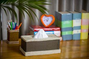A tissue box on a wooden reading table. A tissue box made of fiber. Pineapple leaf fiber. photo
