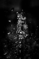 Water liquid splashing on isolated black background. photo