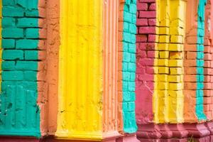 Red, Orange, yellow and blue color combination old Textured damage wall with Colorful Bricks. photo