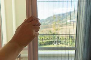 Hand hold pleated mosquito net wire screen handle on house window photo