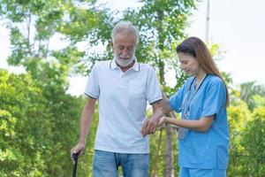 Elderly man talk to doctors and nurses in the hospital. senior male happy after receiving treatment and care and practice walk from a professional doctor. health care, physical therapy, nursing home photo