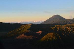 View of Mount Bromo in the morning with the peaks of Mount Semeru in the background photo