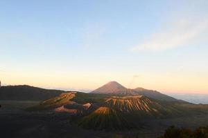 View of Mount Bromo in the morning with the peaks of Mount Semeru in the background photo