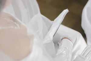 A bride in a wedding dress is holding a piece of paper with the word love on it photo