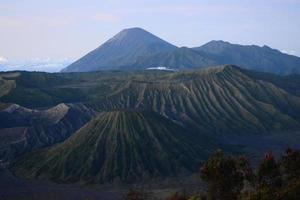 View of Mount Bromo in the morning with the peaks of Mount Semeru in the background photo